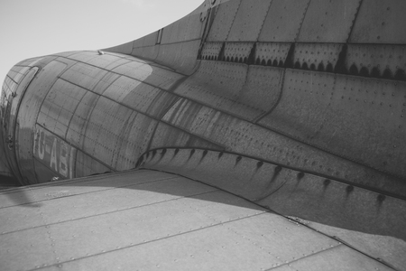 Airplane metallic fuselage detail with rivets. Old silver metal surface of the aircraft fuselage...