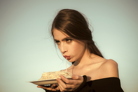 Eating tasty pasta on sunny blue sky backgroundの写真素材