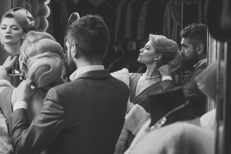 Young man puts necklace on his girlfriend at jewelers shop.の写真素材
