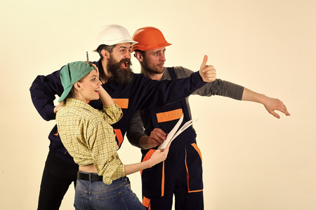 Brigade of workers, repairers and lady happy about results of repair, white background. Brigadier, foreman speak about results of repair, pointing with fingers at side. Success concept.の写真素材