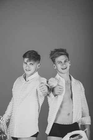 Men smiling and giving thumbs up hand gesturesの写真素材