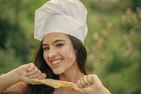 Happy woman tearing raw doughの写真素材