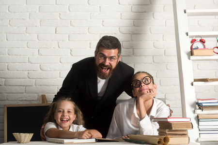 Elementary school kids and teacher sit in classroomの写真素材