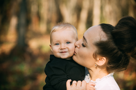 Mothers day concept. Mother kiss little son with love. Woman hug child. Mom and baby boy outdoor. Happy family enjoy sunny day. Love care and trust.の写真素材