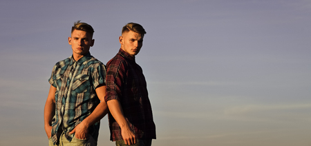 Twins men in shirts outdoors on sunny blue skyの写真素材