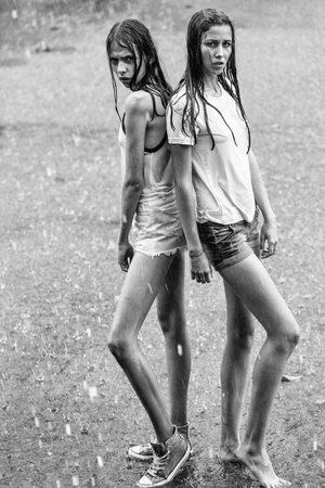 Two pretty girls under rainの写真素材