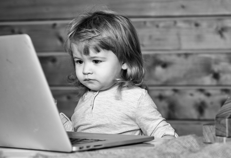 Happy kid having fun. Happy boy near computerの写真素材