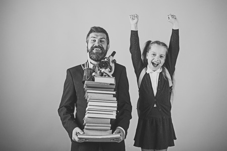 Happy kid having fun. Girl in school uniform and bearded man. Father and schoolgirlの写真素材