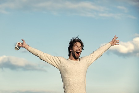 Man with disheveled hair hold cup with mulled wineの写真素材