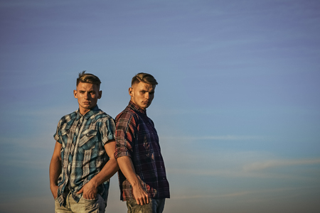 Twin brothers man, relations. Men twins in sunset or sunrise, friendship. Fashion for men, summer. Man twins with athletic body, family values. Partnership, future, support and trust, copy spaceの写真素材