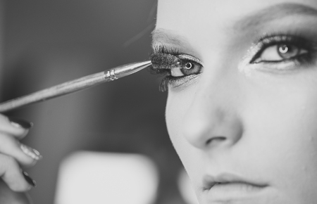 Woman mascara applying brush, female portrait makeup eyelashes.の写真素材