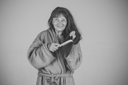 Senior woman in pension and retirement. Woman comb long red hair.の写真素材