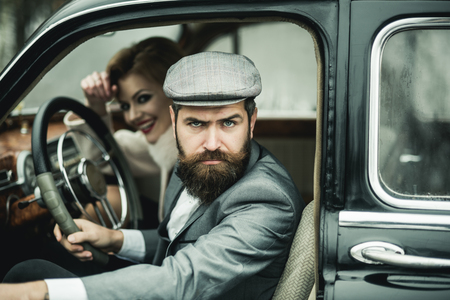 Bearded man and sexy woman in car. bearded man driver on date with sexy girl in retro carの写真素材