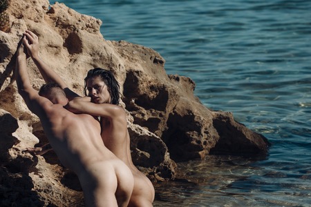 Family and valentines day. Love relations of naked couple in sea water. Couple in love with sexy body relax on beach. Sexy woman and man have sex games. Summer holidays and paradise travel vacation.の写真素材