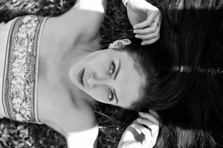 Woman face beauty. Pretty girl or beautiful woman lying on green grass