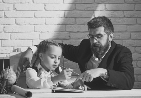 Face fashion little girl or kid in your web site. Little girl face portrait in your advertisnent. Schoolgirl and dad with busy faces learn how to writeの写真素材
