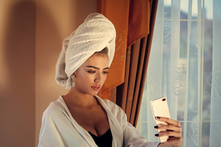 Sensual woman body. Girl with towel on head taking selfie, after spaの写真素材