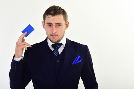 Businessman holding credit card. Man in formal suit holds plastic card and recommends to keep money on bank account. Banking concept. Banker trust in safety and reliability of banking system.の写真素材