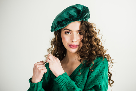 Parisian girl in hat. Fashion woman in green sweater. Retro girl with stylish makeup and hair in paris. girl with curly hair at hairdresser at white wall. Fashion look and beauty concept.の写真素材