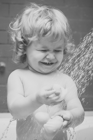Kid play. Happy boy in shower