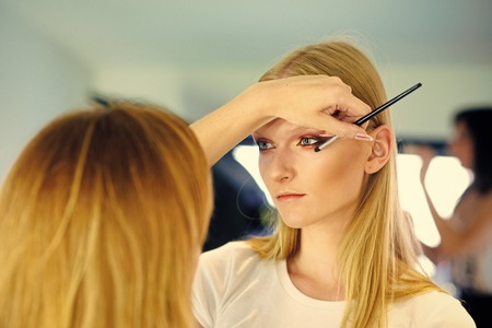 Sexy woman. Visage course and professional make up of girl, skincare. Woman getting glamour eye makeup, look. Makeup artist apply eye shadow with brush, visage. Woman with young face skin in beauty salon.の写真素材