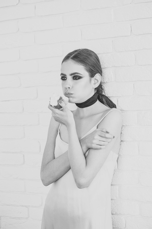Female Face. Issues affecting girls. Woman hold fruit with smokey eyes face makeupの写真素材