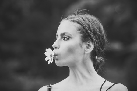 Beauty Fashion model girl. Fashion look. Woman with daisy flower in mouthの写真素材