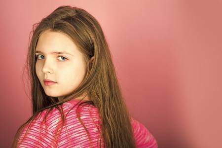 Hairdresser, skincare, casual style, denim. Beauty and kid fashion with cosmetics and healthy hair. Stylish girl with pretty face on grey background. Little girl with long hairの写真素材