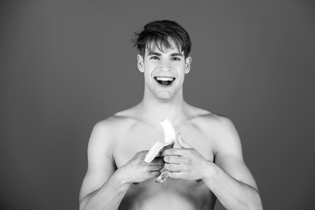 fitness food. dieting and fitness, happy man smiling with bananaの写真素材