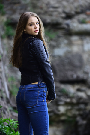 Summer or spring fashion and beauty. girl in casual clothes outdoor. look of girl near stony wall. Sexy woman with long hair at stone. sensual model with makeup after hairdresser.の写真素材