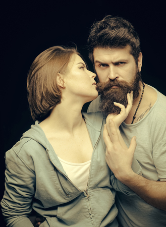 Man with stylish beard. Fashion shot of couple after haircut. Barbershop concept. Woman on mysterious face with bearded man, black background. Man with stylish beard and mustache and girl with fresh haircut, new hairstyleの写真素材