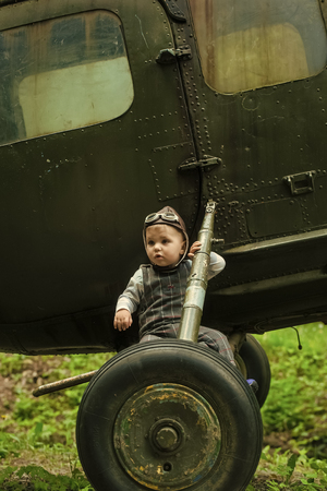 future profession. Child sitting on helicopter wheelsの写真素材
