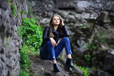 look of girl near stony wall. girl in casual clothes outdoor. Sexy woman with long hair at stone....