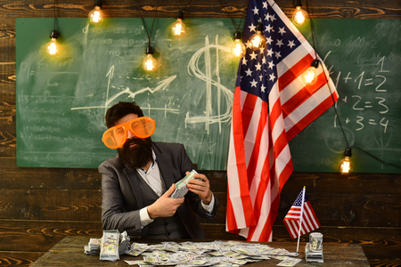 Independence day of usa. Economy and finance. Patriotism and freedom. American education reform at school in july 4. Income planning of budget increase policy. Bearded man with dollar money for bribeの写真素材