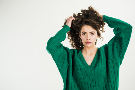 Parisian girl in winter clothes. Retro girl with stylish makeup and hair in paris. Fashion look and beauty concept. girl with curly hair at hairdresser at white wall. Fashion woman in green sweaterの写真素材