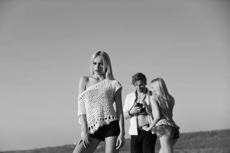fashion photographer. woman posing for photo with couple of man and girlの写真素材