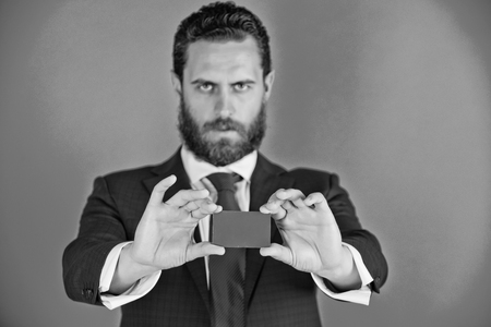 man is holding a business card. man holding credit card on blue backgroundの写真素材