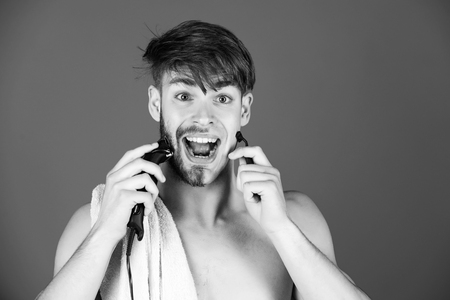 mechanical or electric shaver. guy shaving hair with electric shaver and safety razorの写真素材