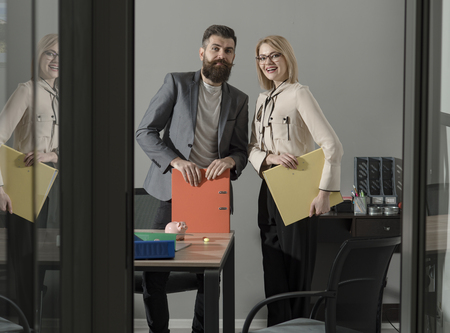 Working and communicating together. Happy colleagues in modern office. Business couple smile meeting...