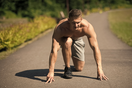 track and field. Man on start position to run on road