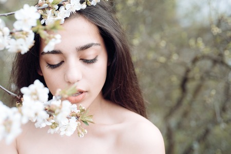Skincare and freshness. Sensual woman with natural beauty look. Spring mood. Beautiful as flower. Arabian woman enjoy flower blossom. Womens day or 8 marchの写真素材