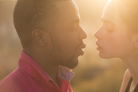 Woman and african American man ready to kiss, summer vacationの写真素材
