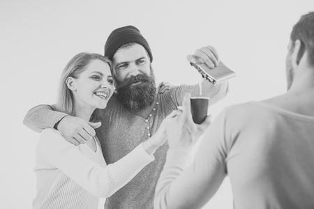 Joint pastime. happy young people , drinking alcohol, close up hands toasting, having fun, friends home party, hipster company together, two men one woman, smiling, positive, relaxed, hang out, laughing.の写真素材