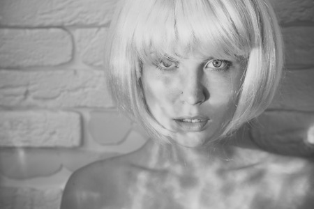 Beauty Fashion model girl. Fashion look. Model with naked shoulders on white brick wallの写真素材