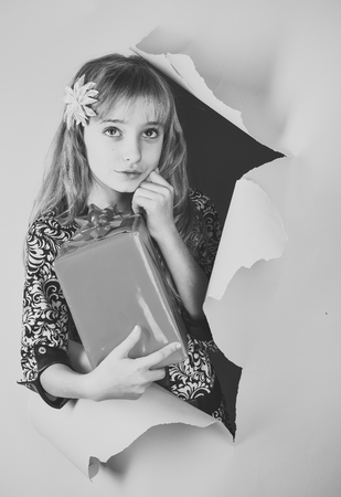 Kids face skin care. Portrait girl face in your advertisnent. Small girl with shopping package, black friday. Birthday and christmas. Childhood and happiness, gift boxの写真素材