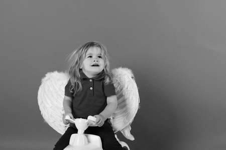 little angel. angel boy for valentine greeting, happy cupid on car toyの写真素材