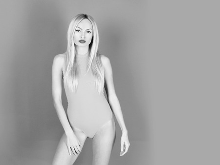 Female fashion, beauty and advertisement concept. Cute girl posing in yellow bodysuitの写真素材