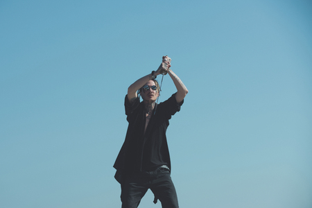 Man training with katana sword on blue skyの写真素材