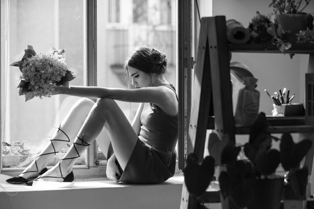 young girl in red dress in orangery with flowerの写真素材