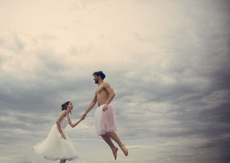 High flying romance. Couple in love fly in clouds. Young woman and man hold hands in sky. happiness and eternal love. Man and woman lovers enjoy romantic love. Happy family and relationshipの写真素材